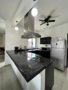 博卡德爾里奧的住宿－Casa Palma，厨房配有黑色台面和冰箱