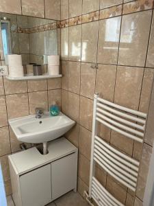 a small bathroom with a sink and a chair at Modesta in Mediaş +4 photos