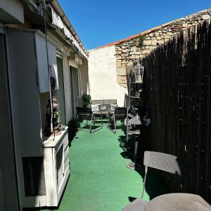 a patio with green flooring and a fence at Loft 80m2 avec sauna, spa, table de massage et billard in Milhaud