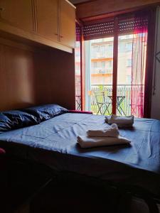 a bed with two towels on it with a window at Viale Aurora in Bibione