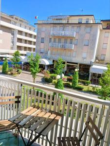 a wooden bench sitting on a balcony next to a building at Viale Aurora in Bibione