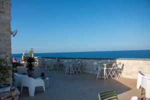 a patio with chairs and tables and the ocean at S. Martin Hotel in Giovinazzo