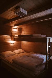 a bed in a wooden walled room with two bunk beds at Vinje Camping in Geiranger