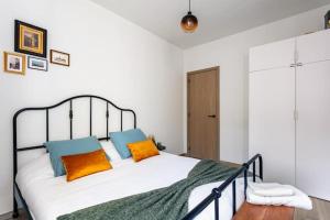 1 dormitorio con 1 cama con almohadas de color naranja y azul en Deluxe apartment suite with terrace, en Amberes