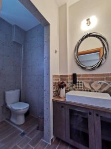 La salle de bains est pourvue de toilettes, d'un lavabo et d'un miroir. dans l'établissement Palio Armonia, à PalaiónTsiflíkion