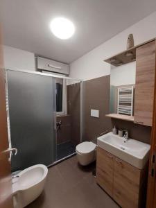 a bathroom with a toilet and a sink and a shower at Nico's Home - Rho Fiera Milano in Pero