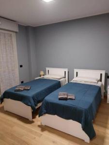 1 Schlafzimmer mit 2 Betten und blauer Bettwäsche in der Unterkunft Nico's Home - Rho Fiera Milano in Pero