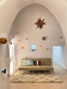 ein Wohnzimmer mit einem Sofa in der Mitte eines Zimmers in der Unterkunft VITA VIVET TRULLO in San Michele Salentino