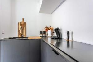 a kitchen with a black counter top in a room at Deluxe apartment suite with terrace in Antwerp