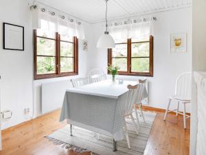 uma sala de jantar branca com uma mesa e cadeiras em 7 person holiday home in Bovallstrand em Bovallstrand