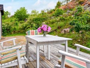 a white table with a vase of flowers on a deck at 7 person holiday home in Bovallstrand in Bovallstrand
