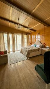 a large bedroom with a bed and a chandelier at The Brigadiers Cottage, Mussoorie in Mussoorie