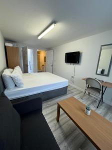 Habitación con cama, sofá y TV. en Posh Executive Studio London, en Thamesmead