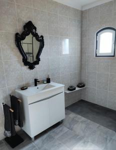 een badkamer met een witte wastafel en een spiegel bij Luar dos Magos in Salvaterra de Magos