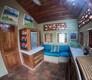a living room with a blue couch and a tv at 'Crows Nest' Studio Apt. in Big Corn Island