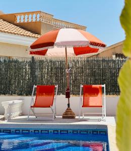 サン・ファン・デ・ロス・テレロスにある2 bedroom villa with private swimming poolのスイミングプールの隣に椅子2脚とパラソル1本