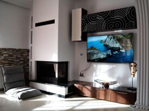 a living room with a flat screen tv on a wall at Villa Nektarina in Afantou