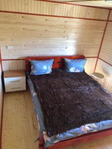 1 cama en una cabaña con pared de madera en Садиба «Пасіка» відпочинок в Карпатах, en Zelena