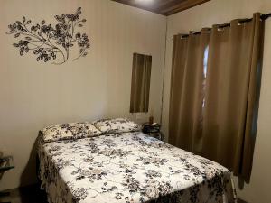 a bedroom with a bed with a comforter on it at Namastê Suítes e Chalés in Sao Jorge