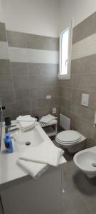 Un baño con un lavabo blanco y un inodoro. en Glamour suite, en Monopoli