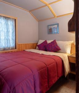 a bedroom with a large bed with a red blanket at Hillside Bungalows in Banff