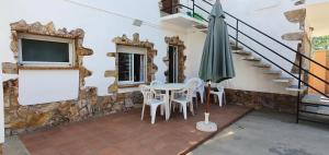 a patio with a table and chairs and an umbrella at Apartament Roqueta in Palamós