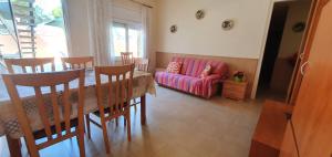 a living room with a table and a pink couch at Apartament Roqueta in Palamós