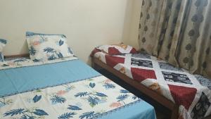 2 letti singoli in una camera da letto con trapunta di Hotel vikash a Barkot