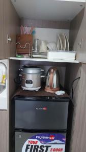 a small kitchen with a stove and some dishes at Zafreen Staycation/CONDOTEL in Manila