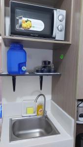 a kitchen counter with a sink and a microwave at Zafreen Staycation/CONDOTEL in Manila