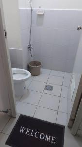 un baño con aseo y una señal de bienvenida en el suelo en Zafreen Staycation/CONDOTEL en Manila