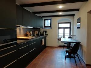 a kitchen with black cabinets and a table at Mittelalterliches Domherrenhaus in Freiberg