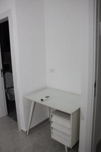 Habitación con escritorio blanco y baño. en וילה במעיין, en Gid‘ona