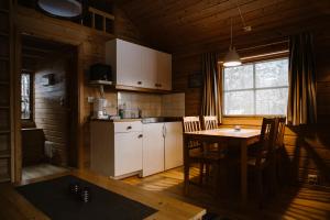 a kitchen with a table and a white refrigerator at Vinje Camping in Geiranger