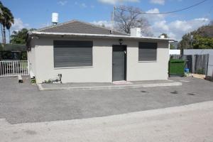 a white house with a door in a driveway at וילה במעיין in Gid‘ona