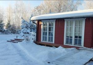 una casa roja con nieve encima en Ramus Ūkis 