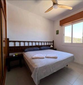 a bedroom with a large bed with a ceiling fan at The three bedrooms Casa Barta - 300m from the beach with a beatiful see view from the terrace and private parking in San Juan de los Terreros