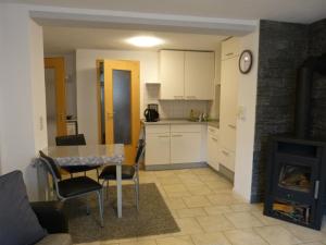 cocina y sala de estar con mesa y fogones en Ferienwohnung Schön, en Münchenbernsdorf