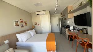 a small room with a bed and a kitchen at Barra Premium residencial in Salvador