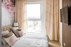a bedroom with a bed and a window at APARTAMENT BOHO in Gdańsk