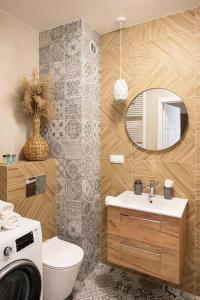 a bathroom with a toilet and a sink and a mirror at APARTAMENT BOHO in Gdańsk