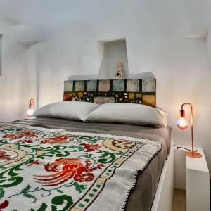 ein Schlafzimmer mit einem großen Bett mit einer farbenfrohen Tagesdecke in der Unterkunft VITA VIVET TRULLO in San Michele Salentino