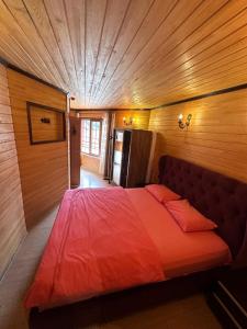 a bedroom with a large red bed in a room at Falay pansiyon in Uzungöl