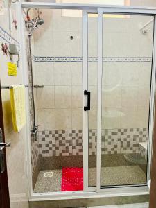 um chuveiro com uma porta de vidro na casa de banho em Casa BB&Djassi em Ponta do Sol