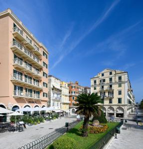 a city street with buildings and a palm tree at Arcadion Hotel in Corfu Town