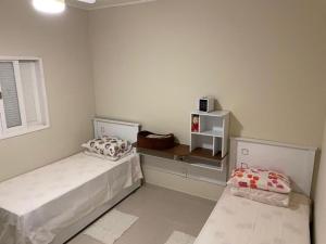 1 dormitorio con 2 camas y ventana en chalé charmoso - Mairinque en Mairinque