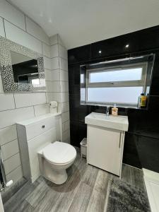 La salle de bains est pourvue de toilettes blanches et d'un lavabo. dans l'établissement Gorgeous Budget Room, à Beckenham