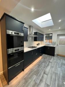a large kitchen with black cabinets and a skylight at Gorgeous Budget Room in Beckenham