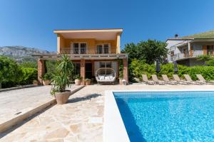 a villa with a swimming pool and a house at House with pool Garden in Žrnovnica