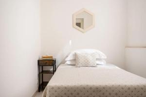 a white bedroom with a bed and a mirror at Casa Dedalu Confortevole Attico a pochi passi dal centro in Fasano